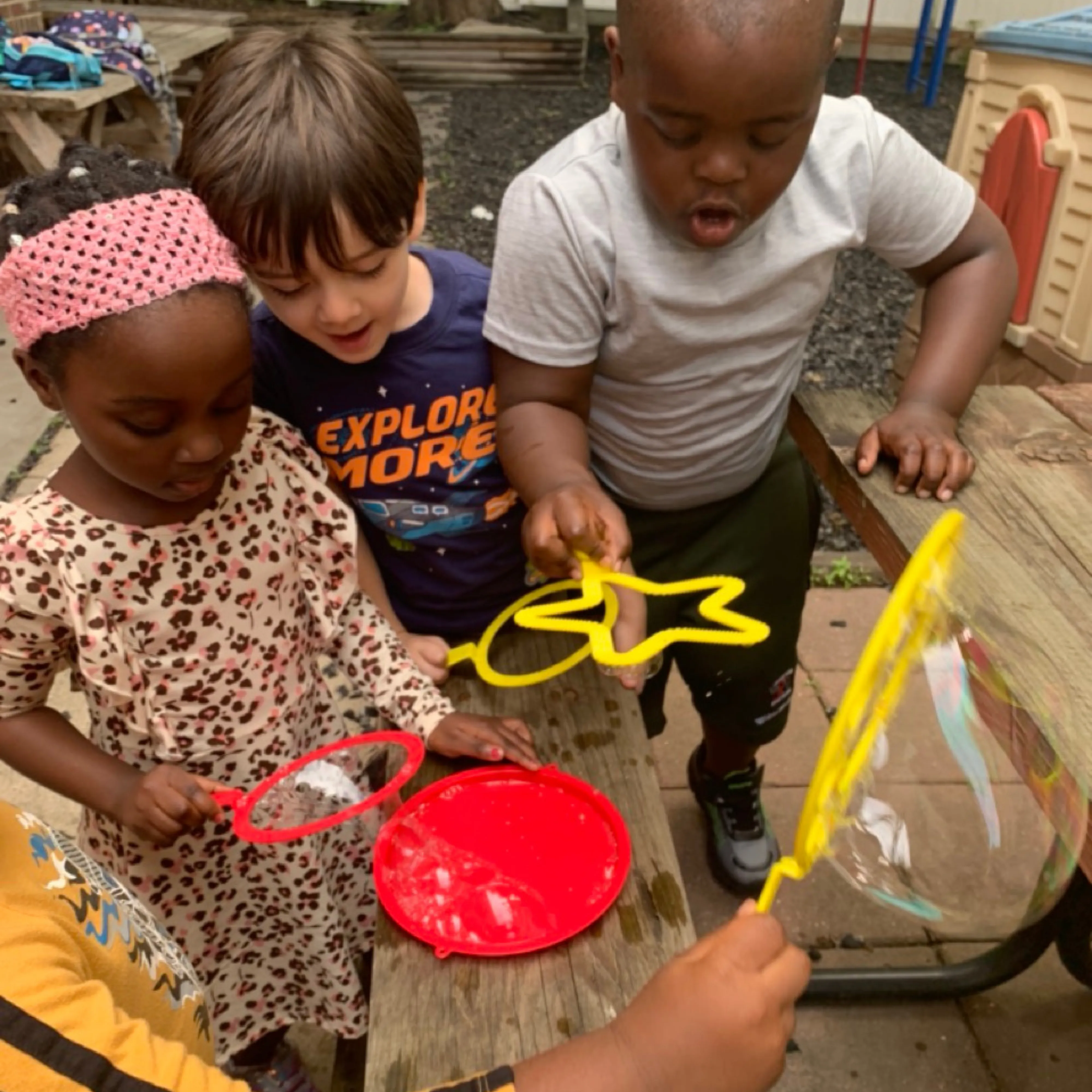 Children chasing bubbles outdoors at summer camp